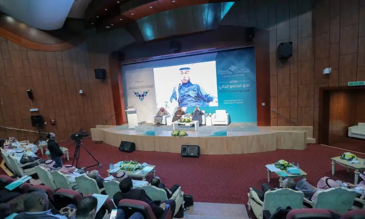 A panel discussion is taking place on the stage in the Great Hall, where scientific sessions are set up for the audience to follow with interest. Khalfin noticed the Arabic text centerpiece and an image of a man wearing the Saudi Arabian Ghutrah, Eqal, and the official Saudi bisht.