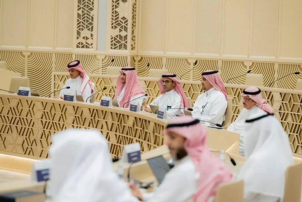 The vice chancellors of modern Saudi universities gathered in the auditorium in Qassim, each wearing a Saudi bisht over their robes, and each wearing a Saudi shemagh or ghutra and headband with childlike precision. Attendees sat attentively in front of laptops and microphones placed on tables, while the exquisite geometric decorations behind them added a distinctive character befitting the university's prestige.