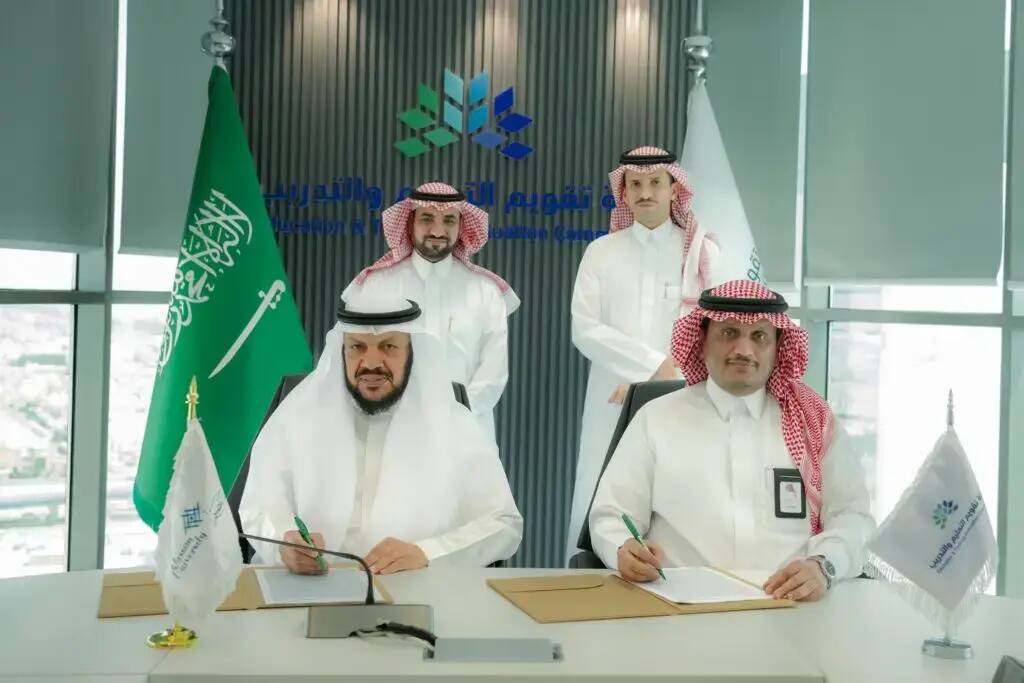 الرجال تولى اللباس السعودي الأصلي الأصلي في بشت سعودي، وغترة أو شماغ، أربعة وقال، يظهرون في المكتب الرسمي. اثنان منهم يتحدثون ويوقعتان وثيقة الصلة باعتماد البرامج الأكاديمية، بينما يتواصلون معهم خلفهم. تجسيد يمين الصورة أعلام المملكة العربية السعودية وهيئة التأهيل الأكاديمي المتميز، بالإضافة إلى شعار الجامعة ونص عربي على صورة الهوية الرقمية للطابعة الرسمية للمكان.