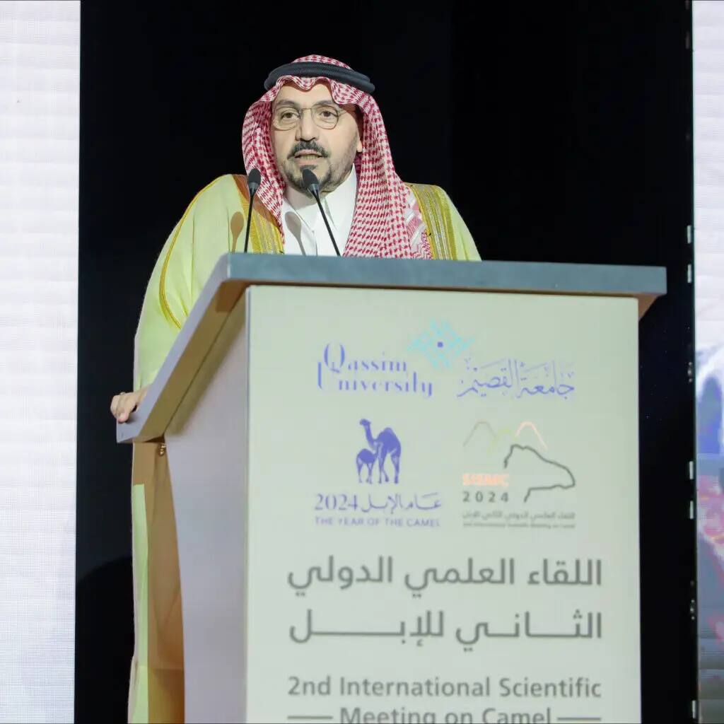 رجل غالبا مرتديا الثوب والشماغ السعودي التقليدي من منصة الخطابة خلال اللقاءات العلمية الدولية الثانية للإبل في جامعة القصيم. لتناول الطعام على المنصة شعارات الجامعة والفعالية، ويحضر هذا الأمر وبعد صاحب السمو أمير منطقة القصيم، بالتأكيد على أهمية الإبل ومكانتها في المجتمع العلمي والثقافي.