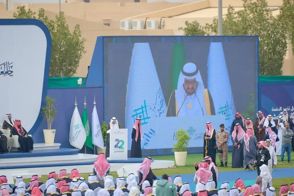 At a major outdoor event in Saudi Arabia, the Emir of Qassim addressed a gathering of Qassim University graduates, who came dressed in the official national uniform with the Saudi Shemagh or Ghutra. His Highness's speech was broadcast on a large-scale projection screen among the audience gathered around the podium to celebrate this national goal.