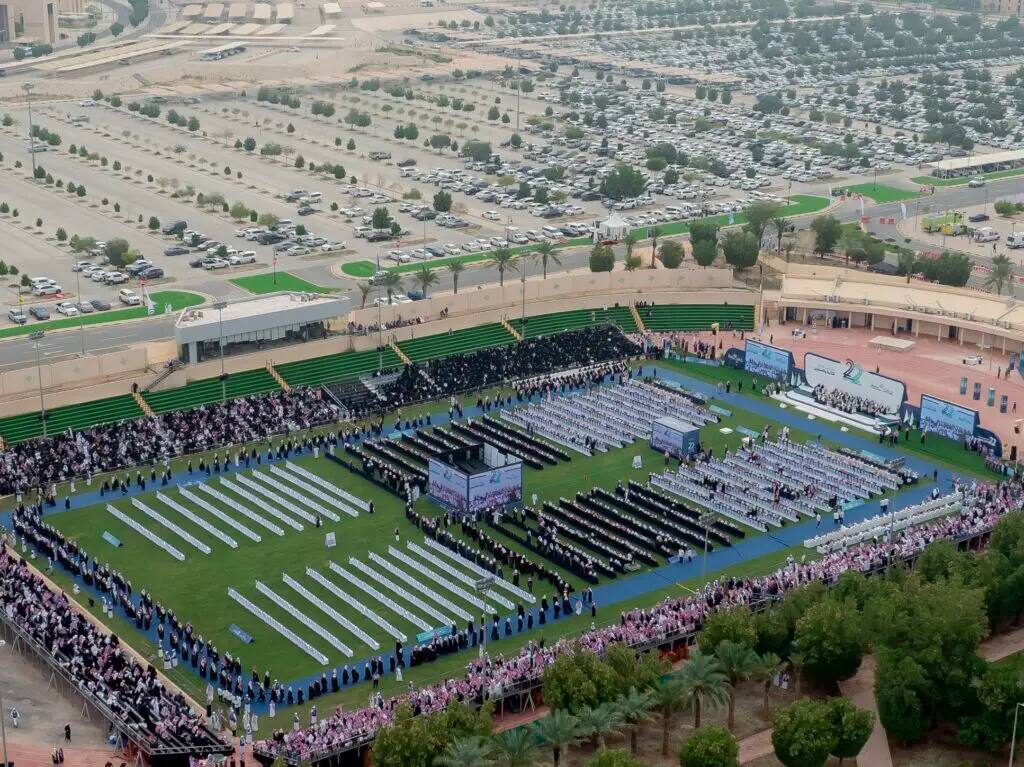 A large crowd gathers in a spacious outdoor stadium, where rows of distinguished attendees, many in Saudi shemagh or Saudi ghutra, line up for a graduation ceremony organized by Qassim University. I stopped looking for the red lines of cars to drive through the manicured green space and towering trees, lending its formal purpose a solemn and majestic air.