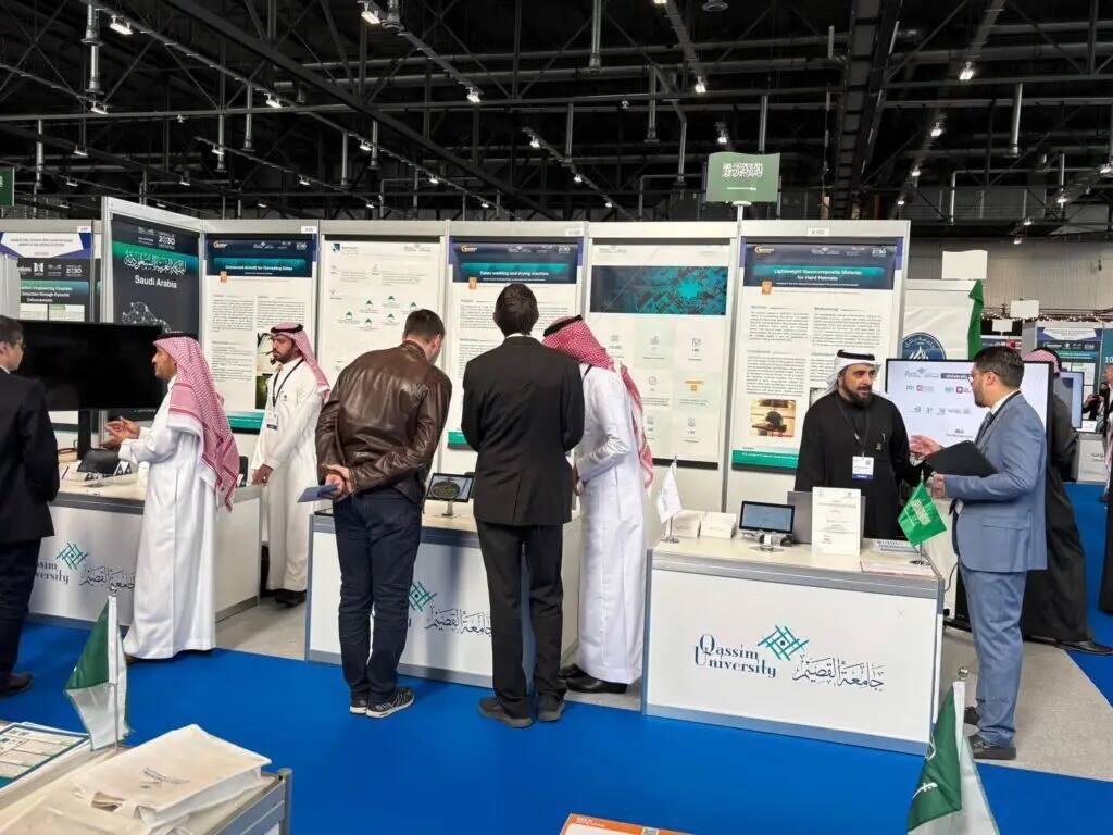 Attendees at the Qassim University pavilion at the Geneva International Exhibition of Inventions (GIEF), dressed in traditional Saudi attire (shemagh or Saudi ghutra) and official uniforms, exchanged pleasantries amidst children and liveliness in the modern exhibition hall. The pavilion highlights the university's achievements through posters, brochures, and outstanding display products that highlight the university's bronze awards at the fair.