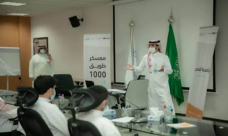 برز أحد الرجال مرتدياً البشت السعودي والغترة مع العقال، مُخاطباً جمهوراً تماماً في قاعة المؤتمرات. وقد زوينت أربعة برايات وأعلام المملكة العربية السعودية، ولم يكتمل بعد "معسكر طويق 1000". وقف رجله وقف آخر يستعرض نصائح LaunchKSA وجامعة القصيم الريادي فيها.