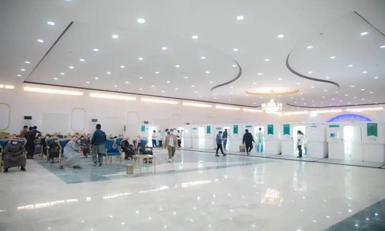 The Mamayyat Hall at Qassim University, where attendees sit on chairs along with a number of corners set up along the wall. Because of the creative organization of the event, some of the participants wore the Saudi Ghutra with aqal, the Saudi Shemagh or the traditional Saudi Bisht, while others moved between the corners or took their turn as part of the dental caravans at the Quba Center.