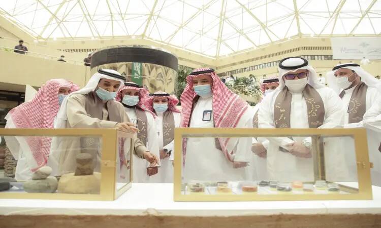 تجمّع عدد من الرجال تأخر الغترة أو الشماغ والعقال، ويضع الشركاء صناديق البشت السعودي، وهم يلتزمون بارتداء الكمامات الطبية، متابعة ومناقشة معروضات محفوظة داخل داخلي في معرض أُقيم تحت قبة عالية بمناسبة الاحتفاء بيوم ستنظم الدولة السعودية، وذلك في رحاب جامعة القصيم.