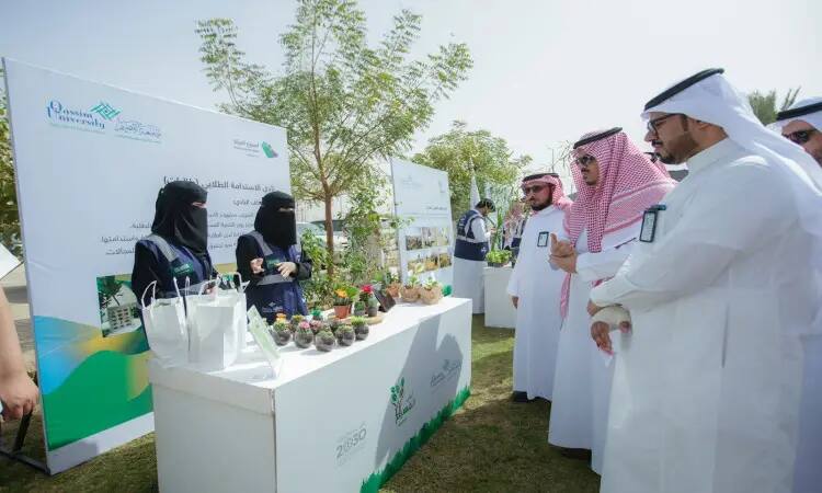 تجمّع عدد من الرجال، تنشأ أصل الغترة أو الشماغ والعقال والبشت السعودي، حول طاولات عرض خارجية مستقلة تدعم منتجات البيئة الخضراء، وذلك ضمن فعالية "حملة أرض القصيم الخضراء" التي نظمتها جامعة القصيم لتعزيز مفهوم الاستدامة. لإعداد ملصقات توعوية ومعلومات حول الفعالية وأهدافها.
