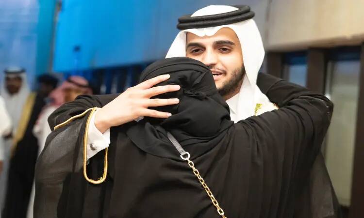 يرتدي الرجل يرتدي الغترة والعقال والبشت السعودي، والدته ترتدي ملابس طويلة وحجاباً أسود، وذلك خلال حضور تخريج الدفعة التاسعة عشرة في القصيم. بسبب عدد من الحضور مرتدين الملابس التقليدية المشابهة.
