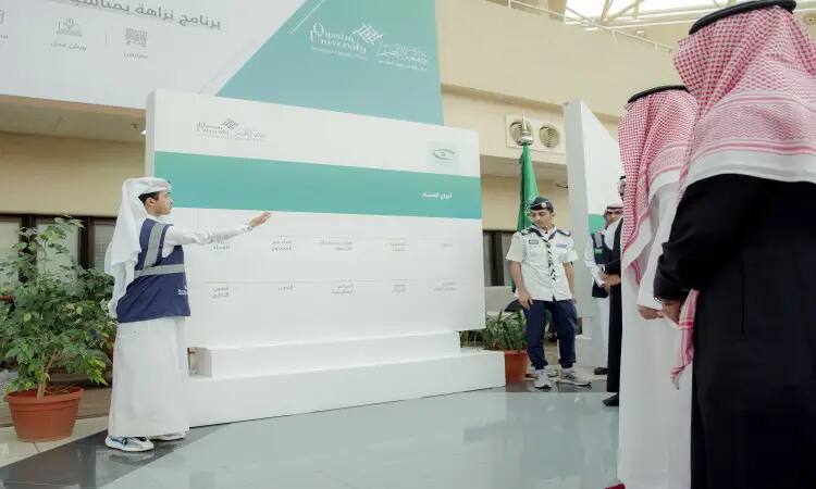 يقوم شاب يرتدي صديرية بالإشارة إلى لوحة عرض سوداء أمام مجموعة من الرجال الذين يرتدون الزي السعودي الرسمي التاسع في الغترة أو الشماغ والعقال والبشت السعودي، ويستعرض جهود المملكة في مكافحة غيره. كما ينقص منها بعض النباتات المزروعة وأحد الناس يرتدون زي الكشافة.