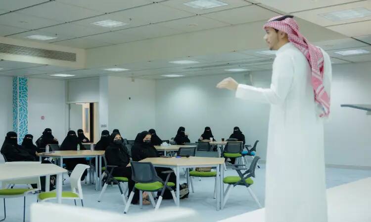 A man in a Saudi ghutra, headband and bisht addressed a group of women, who were forced to wear a black niqab, during the "Technical Career Day" event held in a modern hall in Qassim, which focused on the fields of information technology and technical paths.