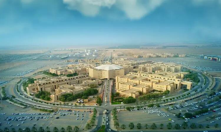منظر جوي لجامعة القصيم، وهو الحرم الجامعي الواسع الذي يضم العديد من المباني المخصصة للأشجار الخضراء ومواقف السيارات. يحتضن فريق الحرم باحثاً متميزاً اختلافاً نوعاً جديداً من سوسة النخيل الأحمر، حيث يظهر بعض أعضاء الفريق وهم كذبت الغترة أو الشماغ والعقال وكذلك البشت السعودي، ما يعكس التوقيع الرسمي الأصيلة للجامعة. للبحث عن الصحراء وتزين السماء الزرقاء الغيوم المتفرقة في دلالة أصالة المكان وريادة البحث العلمي في الجامعة.