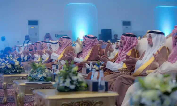 A group of men dressed in the Saudi Arabian ghutra or shemagh, aqal and bisht, led by the Emir of Qassim, sat on elegant chairs and applauded during the fourth university campaign to raise awareness. The venue was characterized by blue lighting and beautiful arrangements on the tables, adding a solemnity befitting the dignity of Qassim University and its leaders.