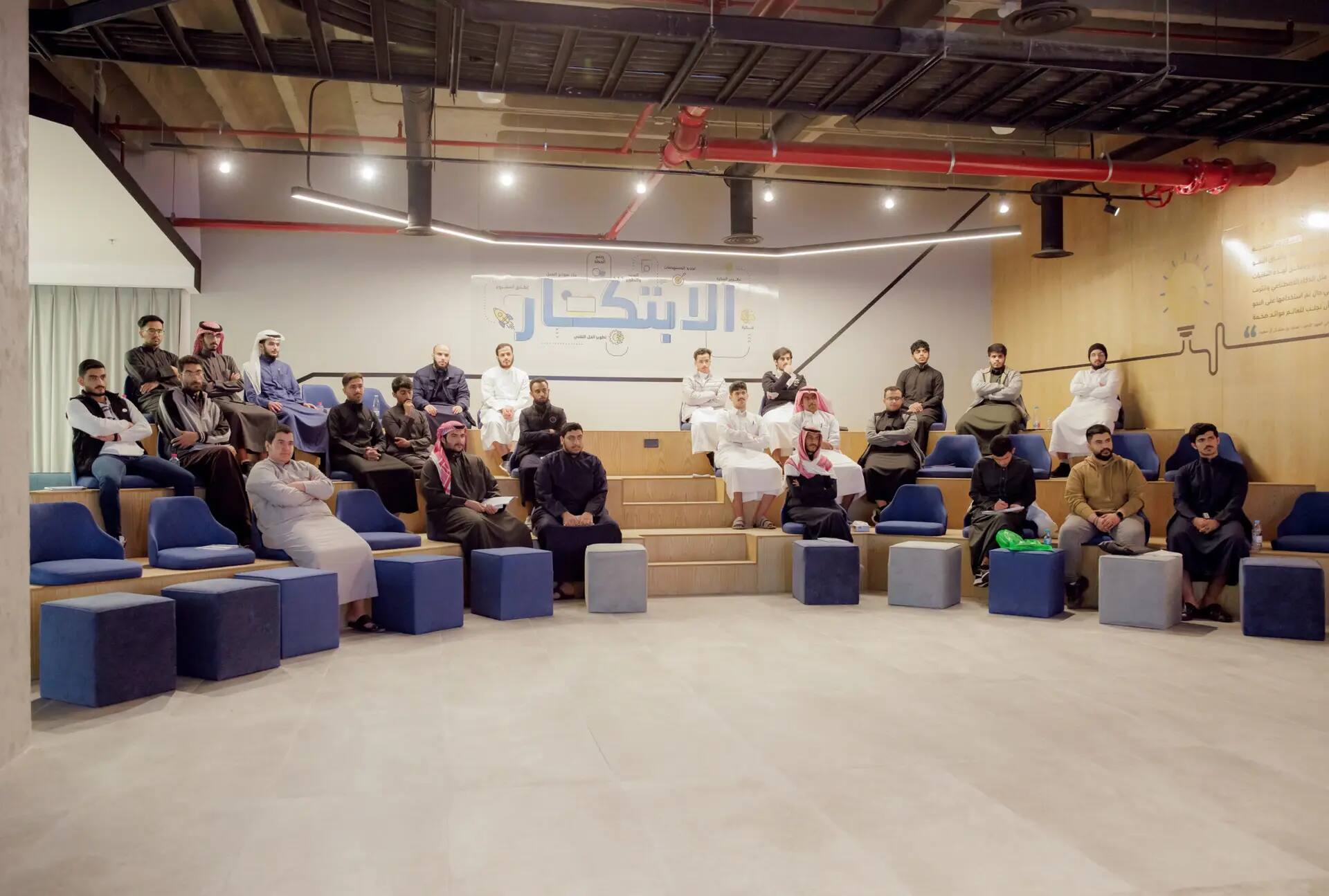 يجلس مجموعة من الأشخاص، ولا يظهرهم من الرجال الشماغية السعودية التقليدية، على مساحة حديثة إلا بلمسات خشبية وكتابات عربية على الجدران، وهي مناطق جذابة في القصيم وتدعو الزوار إلى اكتشاف المنطقة.