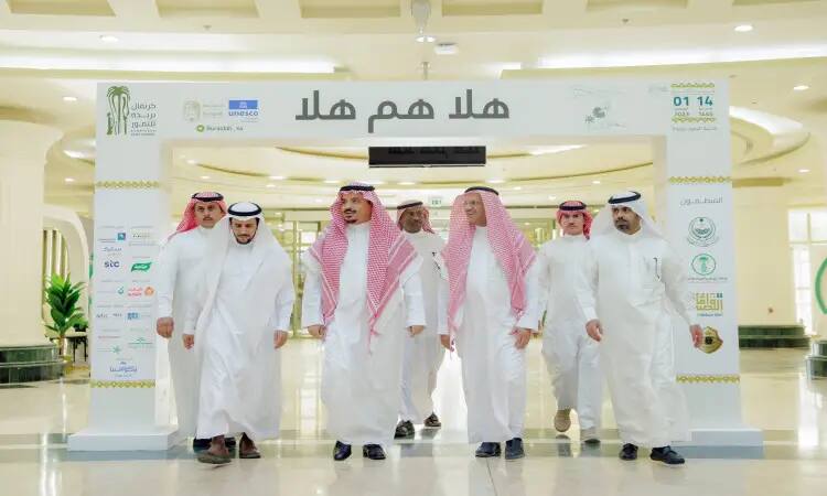 ويقضي عددٌ من الرجال مرتدين الغترة أو الشماغ والعقال والبشت السعودي وتحت إشراف نيوكليوت تحمل نصًا عربيًا في كرنفال بريدة للتمور، وذلك داخل قاعة مغلقة تبرز فيها شعارات ولافتات وجناح الجامعة في الخلفية.