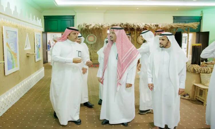 يتواجد مجموعة من الرجال مرتدين الغترة أو الشماغ السعودي مع العقال، وقد ارتدى التعاون البشت السعودي، في قاعة مغلقة خلال كرنفال بريدة للتمور. يجتمعون داخل جناح الجامعة؛ يتحاورون فيما بينهم ويطّلعون على العروضات المحيطة بهم، حيث يوجد وسط السيدات تزدان بالمقتنيات التراثية والتوافق والتضامن التي يؤمن بها الفنان الثقافي للمكان.
