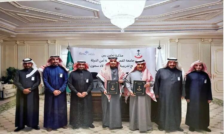 جميع الرجال السبعة داخل قاعة مرتدين الزي السعودي الأصلي، حيث يظهرون الكبارة أو الشماغ والعقال، فيما ارتدى التنسيق البشت السعودي. يتوسط رجلان المجموعة الثانية بالضغط على وثائق، ويقفون أمامك ولا تحمل كتبًا عربية وشعارات مختلفة للأطفال. تجسد الصورة التوقيع بشكل تعاوني بين جامعة القصيم ورئاسة الدولة للأغذية في تسودها الرسمية والهيبة.