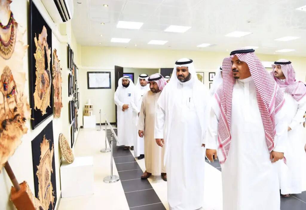 وتشاهد مجموعة من الرجال مرتدين الغترة أو الشماغ السعودي مع العقال والشت السعودي، والأعمال الفنية حتى تنتهي إلى إحدى قاعات المعارض المضاءة بشكل جيد في جامعة القصيم. وقد تمتلك بعض هذه التصميمات ونقوشات عسكرية دقيقة من رؤية 2030.