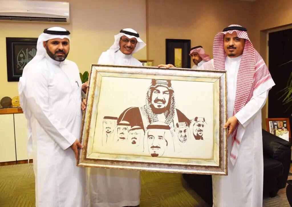 رجال تألقوا بالبشت السعودي والغترة أو الشماغ والعقال، الاتصالون في أربعة مكان مغلق مبتسمين، واثنين منهم بحمل عمل فني مؤطر يبرز صور بما في المملكة العربية السعودية، وذلك من خلال معرض "موضة فن" الذي نظمته كلية التصاميم والمنزل في القصيم.