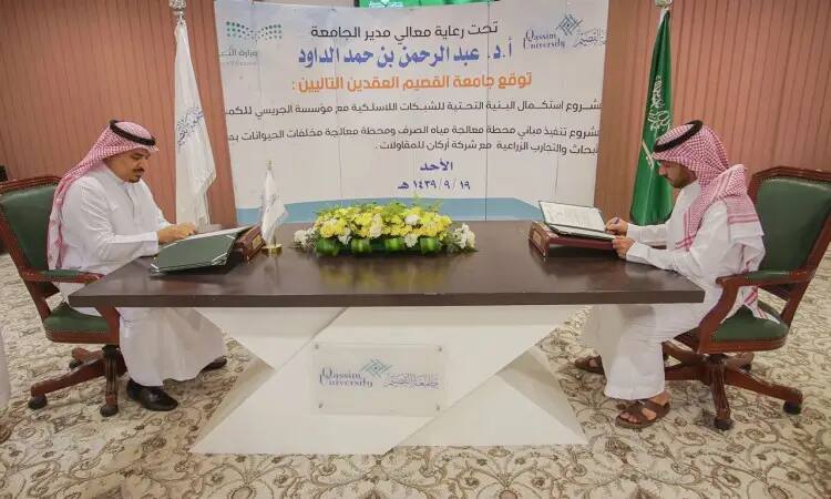 يجلس رجلان ويرتدي الغترة السعودية والشماع والعقال والبشت السعودي حول طاولة، ويقومان بتوقيع وثيقة التخرج. وتوصلت إلى خلفهما شعارات جامعة القصيم، وعلمت المملكة العربية السعودية، إلى جزء من الزهراء الأنيق. كما يتساءل الكثير يتحمل نصاً عربياً يتناول موضوع الشبكة اللاسلكية.