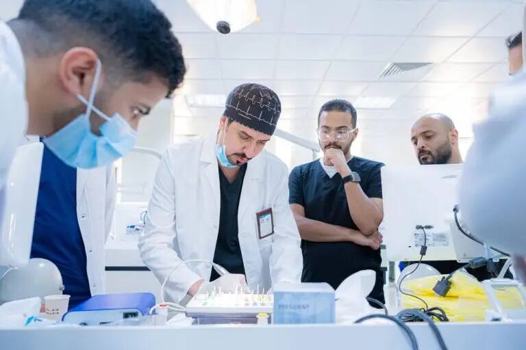 يتجمّع عدد من الرجال، تنشأ المنظمات المتعاطفة والخبرية والكمامات، حول طاولة مختبر في طب الأسنان بكلية طب الأسنان. ويركزون عليهم على عرض ما يقدمه أحد الحضور مرتدياً معطفاً أبيض وغترة سعودية ذات نضوج، وذلك ضمن تعليم الأطفال في القصيم.