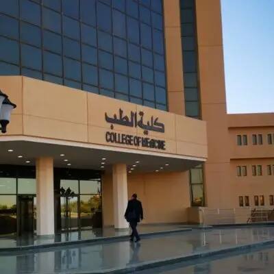 يتقدّم أحد الأشخاص، مرتدياً شماغاً سعودياً أو غترة سعودية، نحو مدخل حديث تزينه نوافذ واسعة وجدران بلون البيجون تظهر لوحة عند المدخل تحمل عبارة "كلية الطب" و"قسم الطب النفسي" باللغتين العربية والإنجليزية.