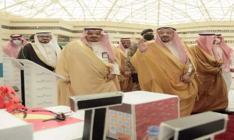 تجمّع عدد من الرجال مرتدين الغترة أو الشماغ السعودي مع العقال والبشت السعودي، إلى جانب أعضاء من الجلسات العسكرية، في قاعة ضمن فعاليات معرض مبتكر 2022. جمعية الجولة الرسمية، شارك أحد الحضور بينما تابع باهتمام ما يتم عرضه على طاولة مخصصة لاستعراض ابتكارات الطلبة المتميزين من جامعة القصيم.
