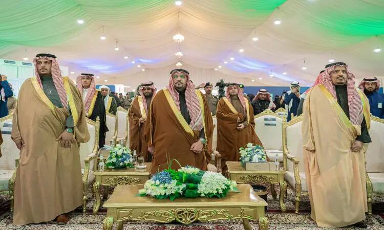 Calling a group of Saudi men in their original attire, where the tunic or shemagh and the Saudi bisht are emphasized, inside an ornate tent from which a lamp hangs. These gatherings are part of the Qassim University's education system, and are part of the university's diversity program.