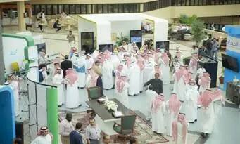 مجموعة كبيرة من الأشخاص، معظمهم من الرجال الشماغ أو الغترة السعودية، يجتمعون في معرض أو فعالية ما يتعلق بأجنحة ومناطق الجلوس، حيث يناقش تقرير في كل الأطفال ومنظمة.