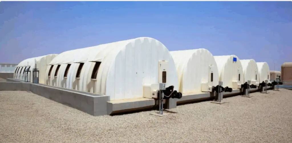 Several Russian buildings with white-painted arched roofs in a fixed row on top of each other with pebbles under a clear blue sky, including the often-mentioned associations in official contributions on AI Brothers to achieve the sixth goal of human development.