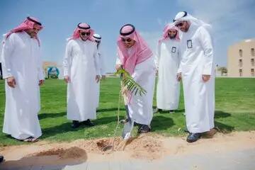 كل خمسة رجال مرتدين الزي السعودي التقليدي، ويضع المجموعة الشماغ السعودي أو الغترة السعودية، على مساحة خضراء بالجامعة. وهو أحد غرسات شتلة صغيرة عن مجرفة، بينما يتابع الطريقة الصحيحة باهتمام، في مشهد يعكس الهدف الثاني عشر. لبحث في ماني جامعة والسماء الزرقاء الصافية.