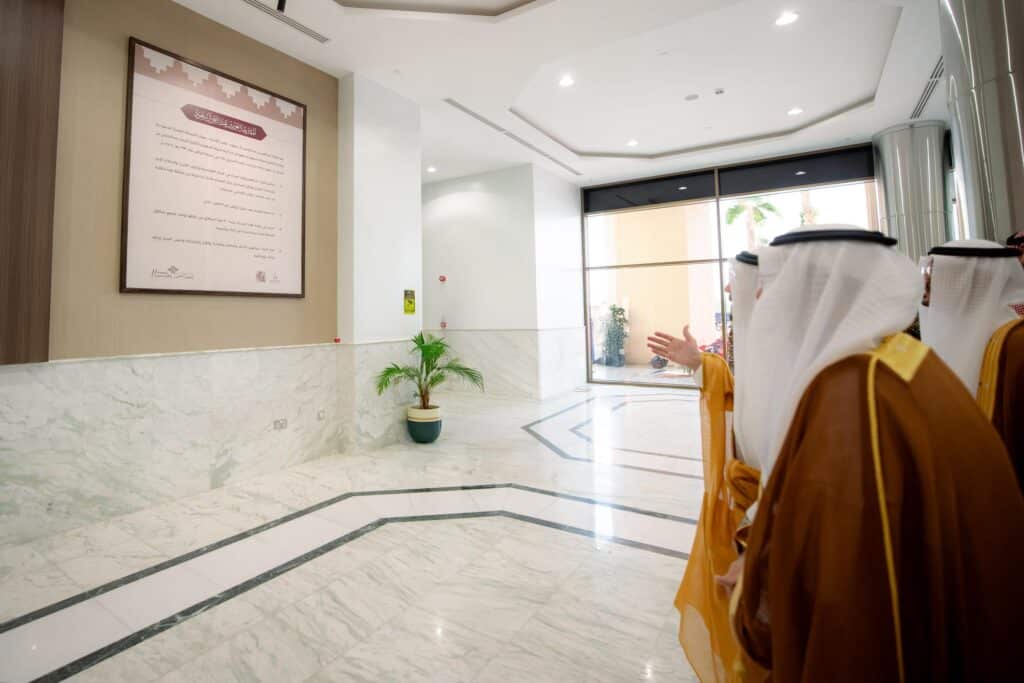 Officials inspect an official document during the university's National Day celebration at the Qassim University Auditorium.