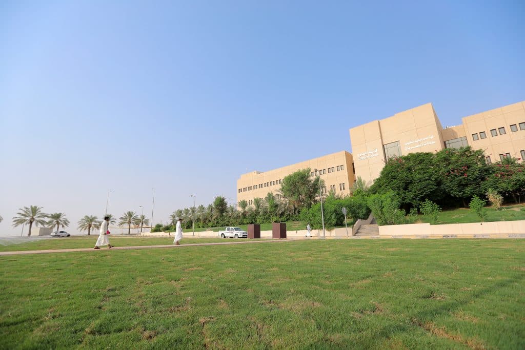 خض مساحات واسعة أمام مبنى جامعة القصيم مكتوب عليه بالعربية، تعكس بيئة أكاديمية سعودية.