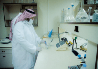 باحث بجامعة القصيم يعمل في مختبر يحلل المياه ويطبق إجراءات حماية البيئة.
