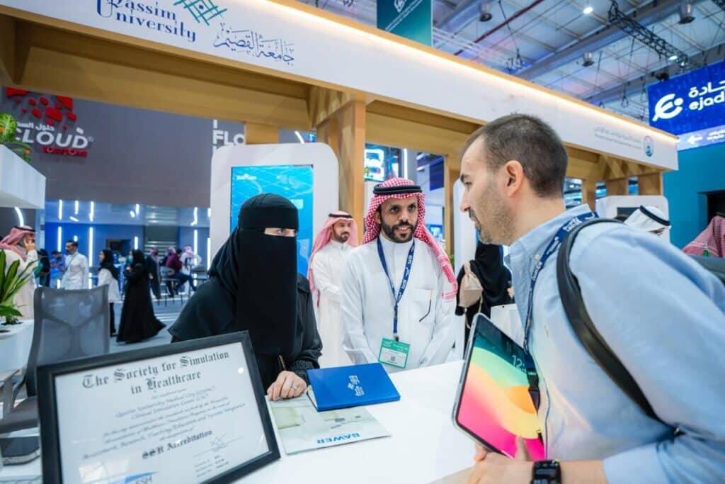 ممثلون من جامعة القصيم يناقشون أكاديمية مع زائرون خلال ملتقى الصحة العالمية.