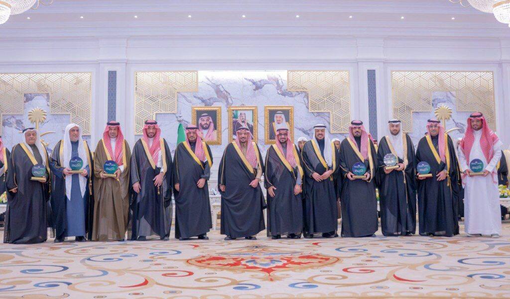 تكريم رسمي أكاديمي في جامعة القصيم بحضور أمير المنطقة وأعلام للجامعة والكلية التطبيقية.