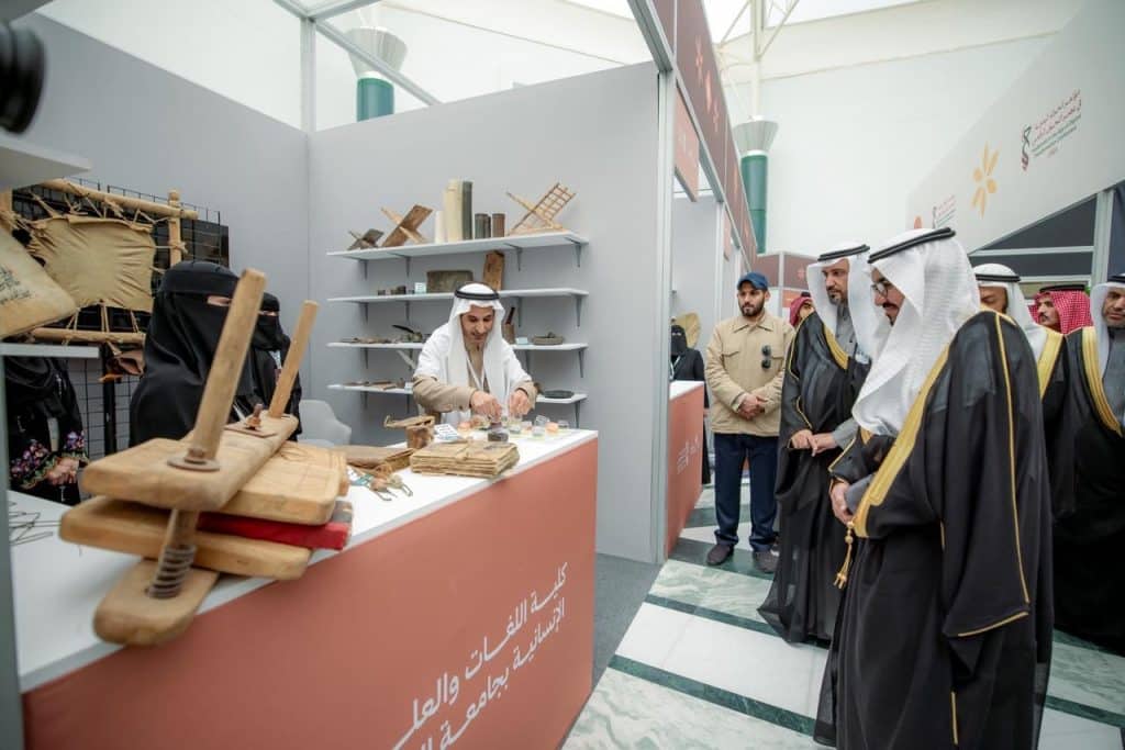 زوار في معرض معرض القصيم يتابعون عرض الحرف اليدوية ضمن فعالية أكاديمية ثقافية ثقافية.