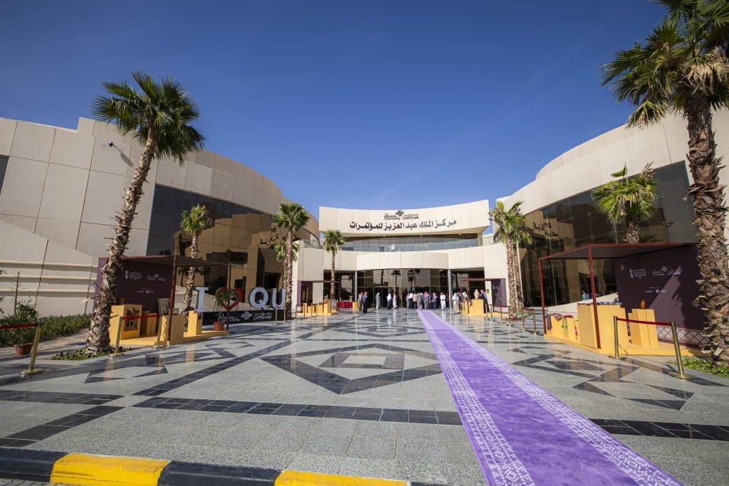 Qassim University's new modernized entrance with a conference banner and an event discussing digital transformation.