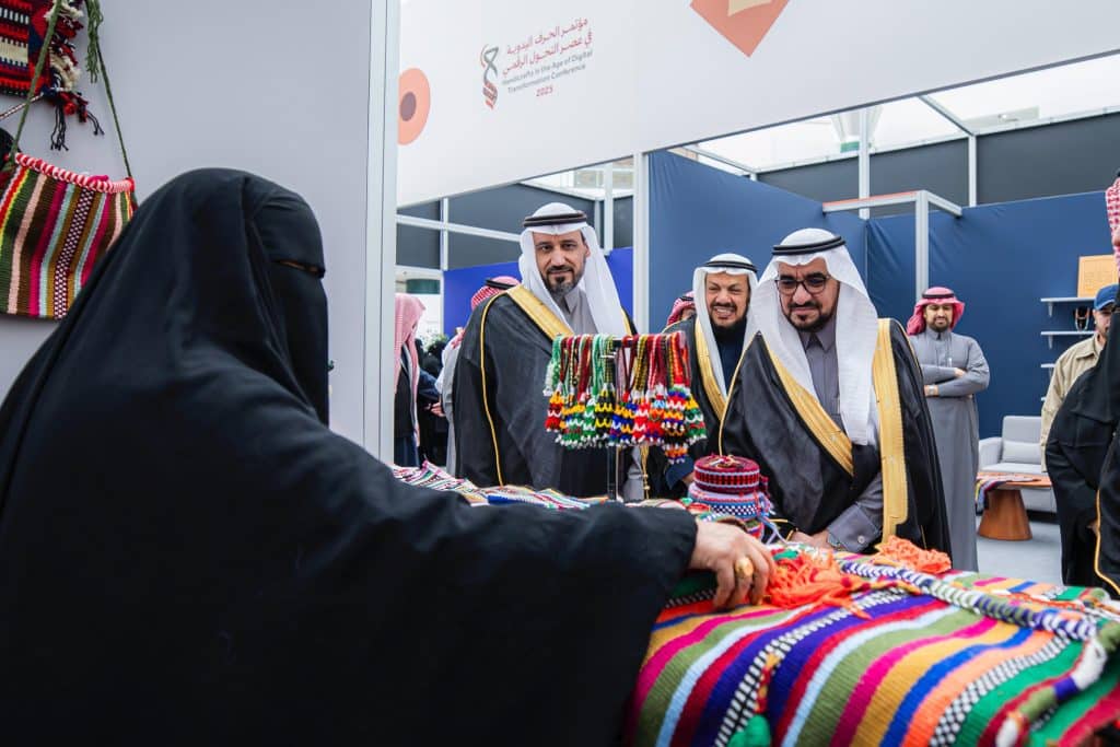 Showcasing Saudi handicrafts to visitors at a cultural pavilion at an exhibition organized by Qassim University.