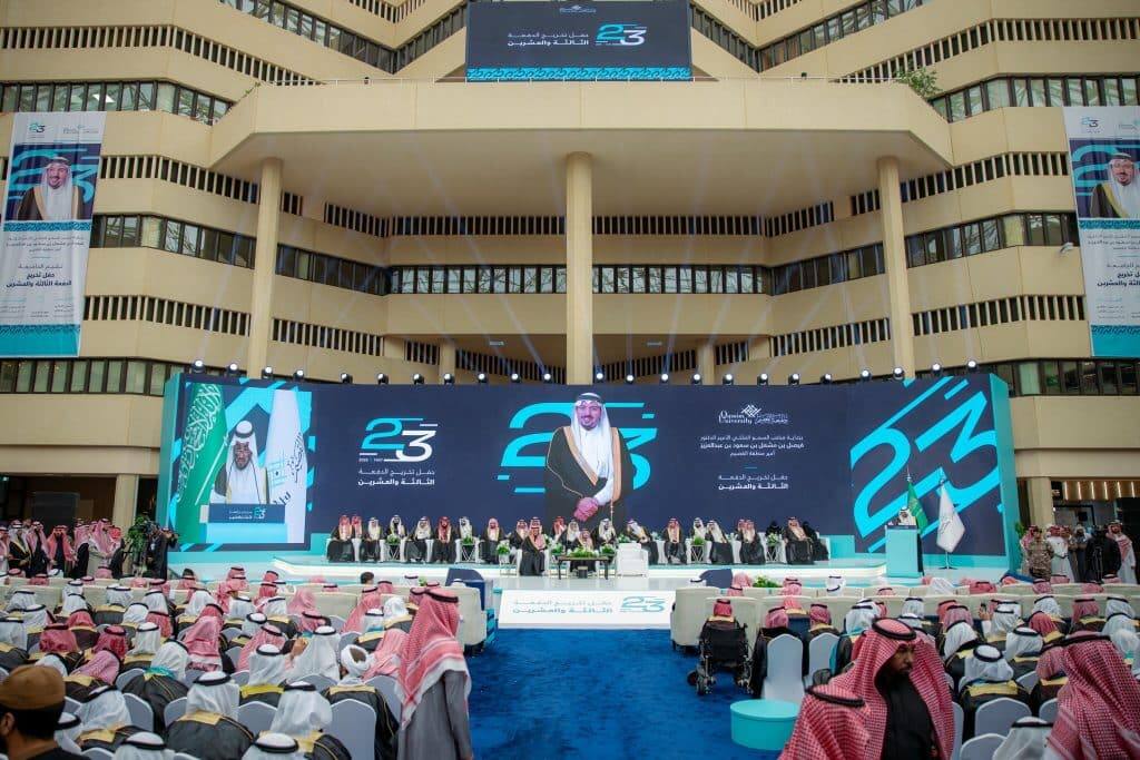 The graduation ceremony of the 23rd class of Qassim University with speakers and the logo of Saudi Vision 2030.