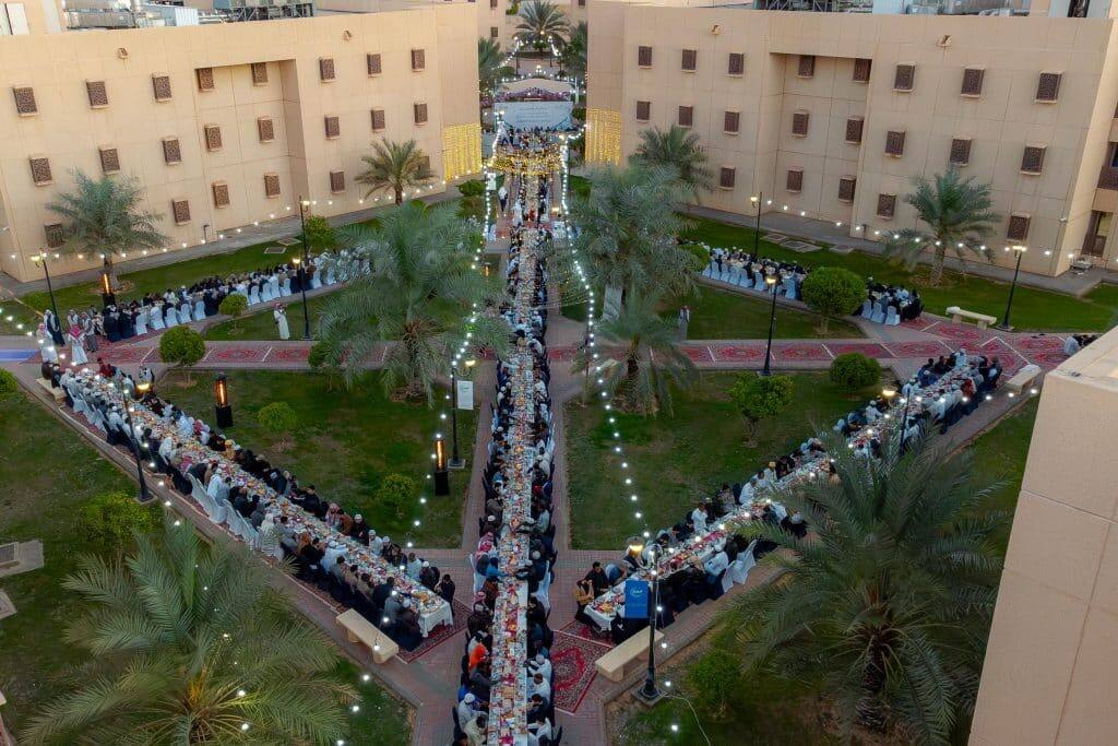 إفطار رمضاني جماعي في جامعة القصيم، بتنظيم أكاديمي بين المباني وتزيين بالنخيل والأنوار.