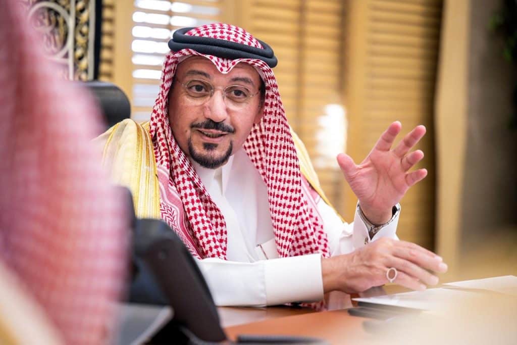 A faculty member discusses university programs in his office at Qassim University within a Saudi academic environment.