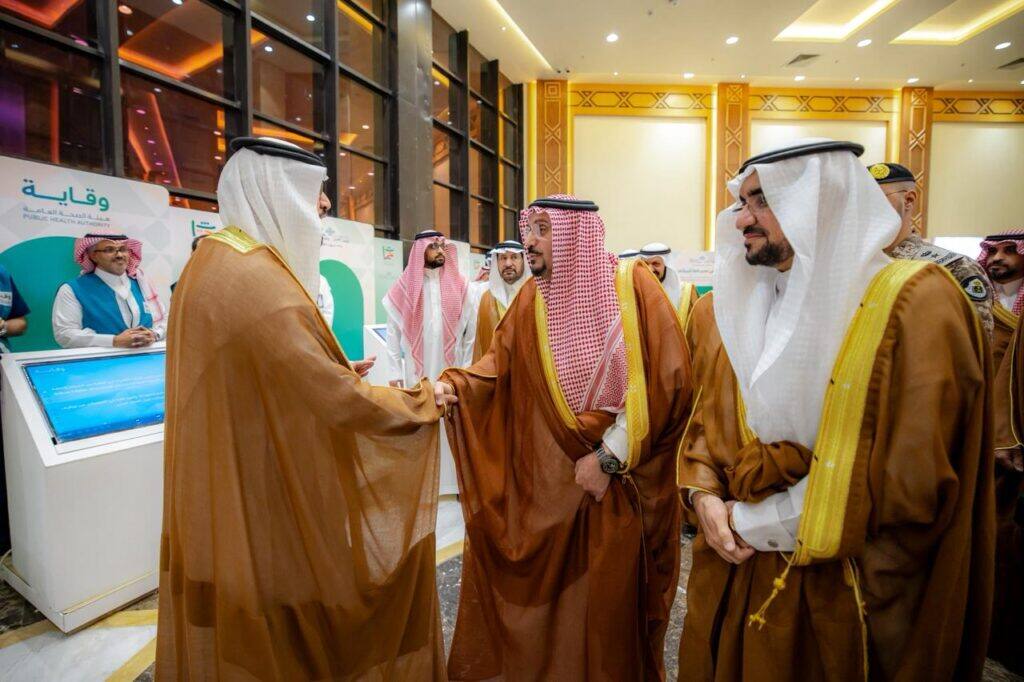 Members of Qassim University interact at the Peoples' Heritage Festival in a formal academic environment.