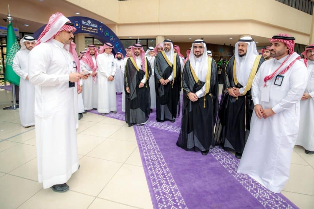 جامعي يستمع لكلمة رئيس جامعة القصيم في معرض كلية العلوم، إبرازًا لبصمة إنجاز.