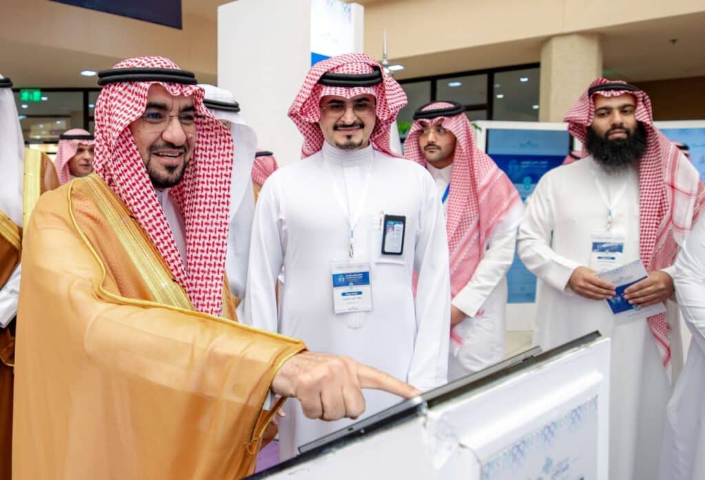 Officials from Qassim University follow a technical presentation during the Scientific Engineering Forum.