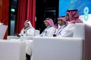 ندوة علمية بجامعة القصيم ضمن الملتقى الهندسي، أحد المشاركين يتحدث أمام شاشة الحدث.