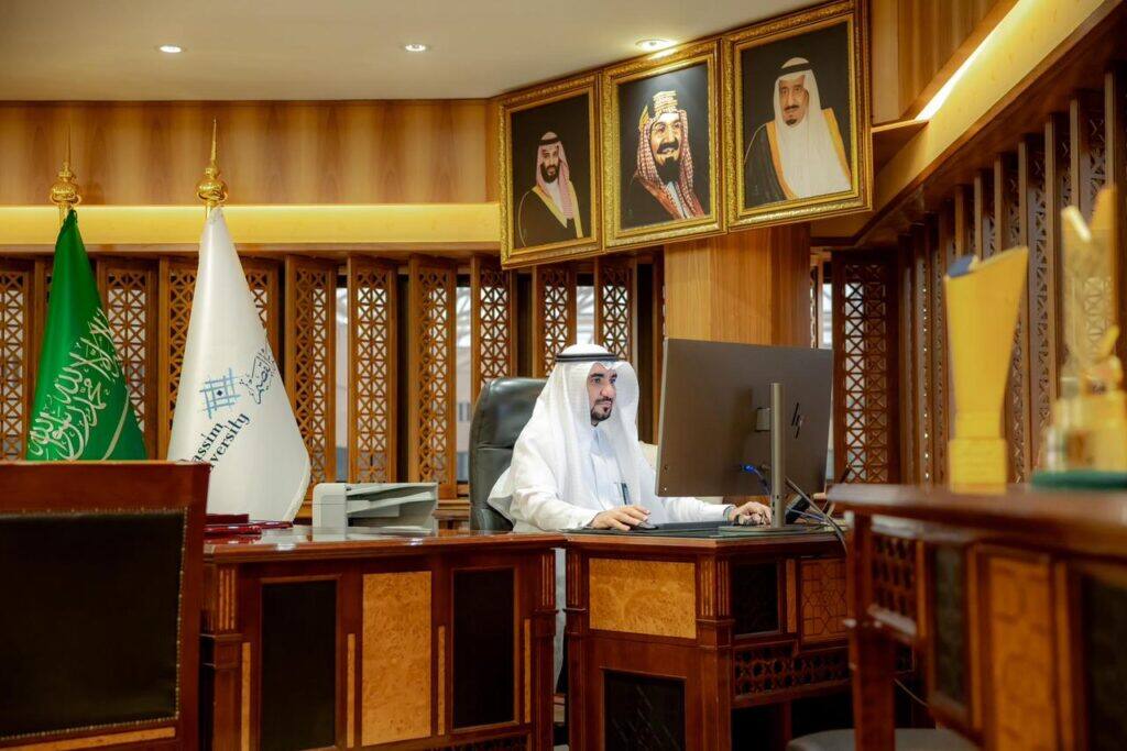 An academic official at Qassim University performs his duties in an official office that reflects Saudi values and identity.