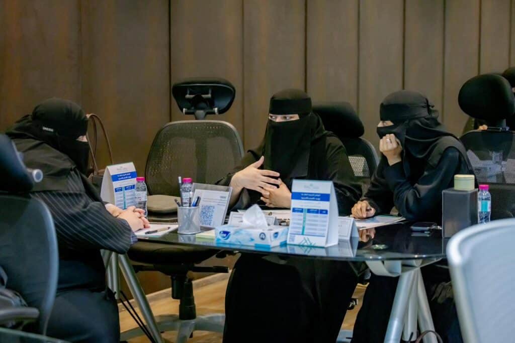 An academic discussion for a women's team about the intensive training program at Qassim University in a women's meeting room.