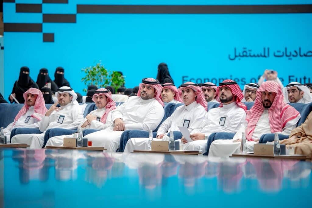 حضور أكاديمي رسمي في مؤتمر يوم البحث والابتكار 2026 جامعة القصيم مع شاشة عرض خلفية.