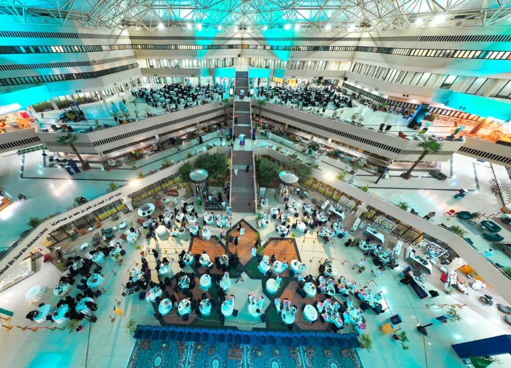 Academic event for national entities and innovators in a modern hall at Qassim University.