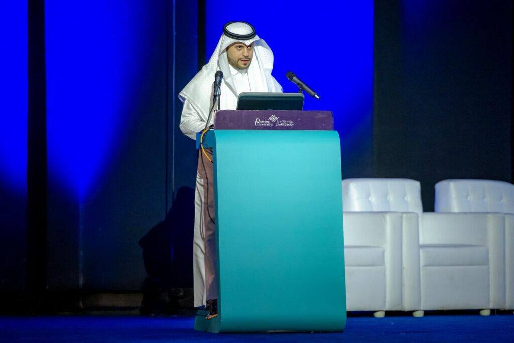 A speaker delivering a speech at the research forum of the College of Agriculture and Food Sciences at Qassim University.